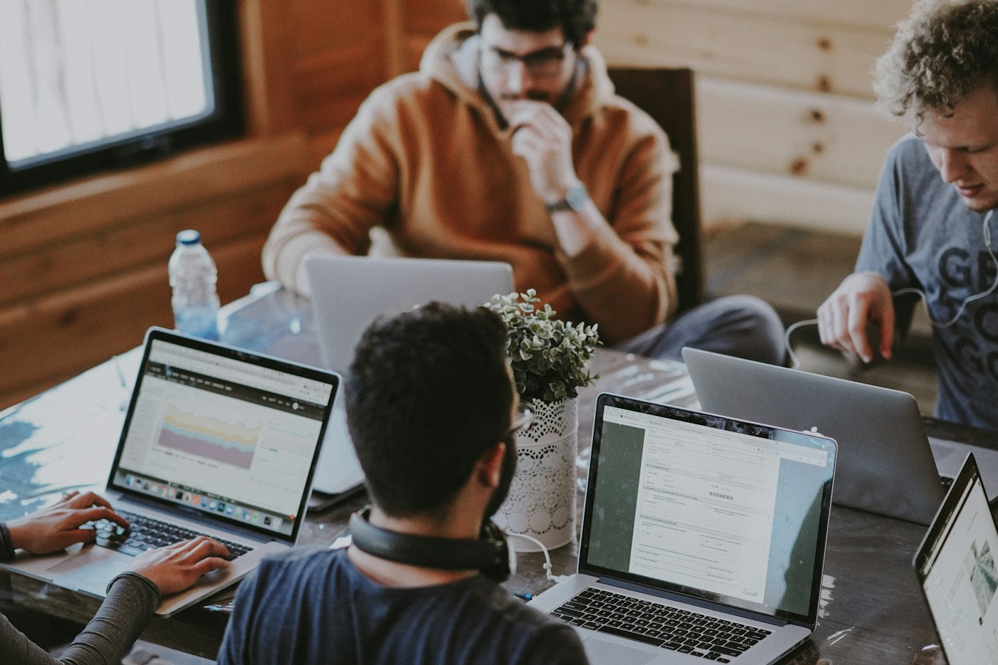 A small team working on laptops together around a shared table
